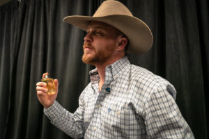 Cody Johnson spraying his cologne back stage before a concert